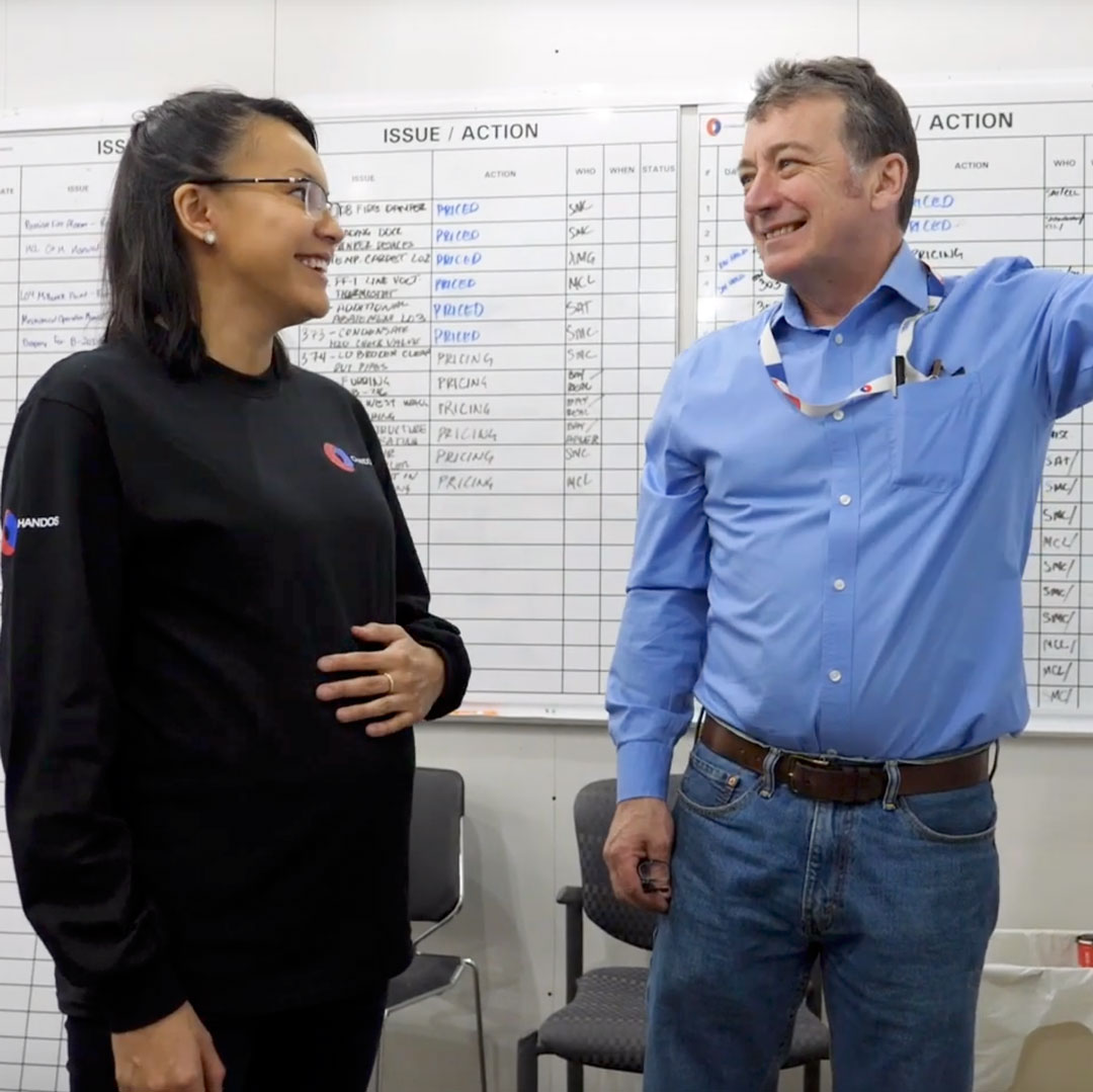 Two co-workers standing in front of a whiteboard