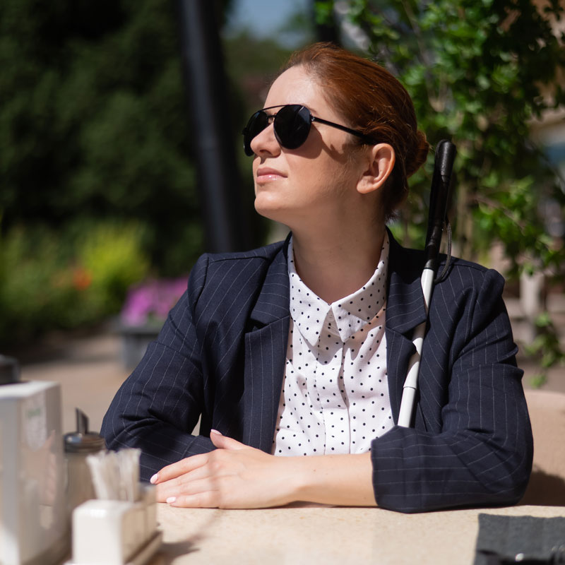 A blind women sitting outside