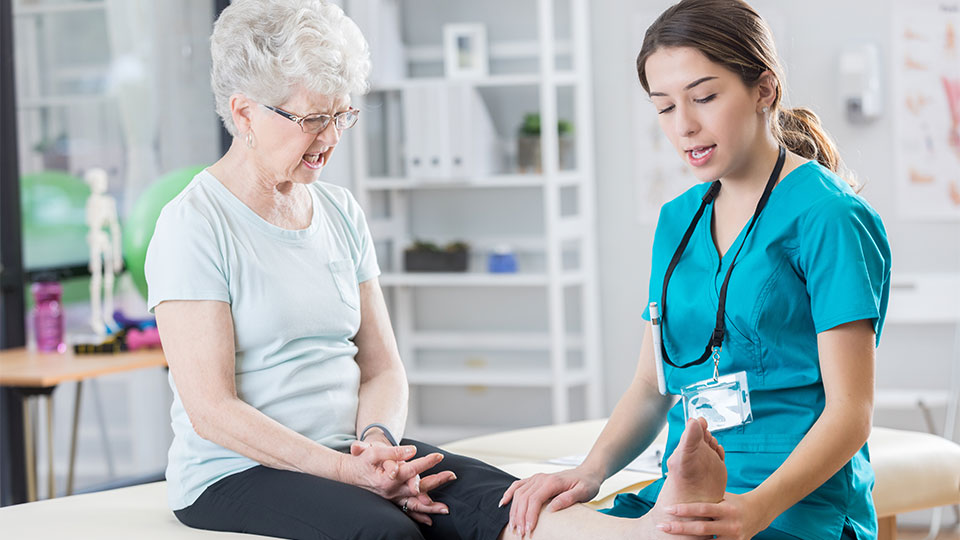 A young female nurse helping an elderly women