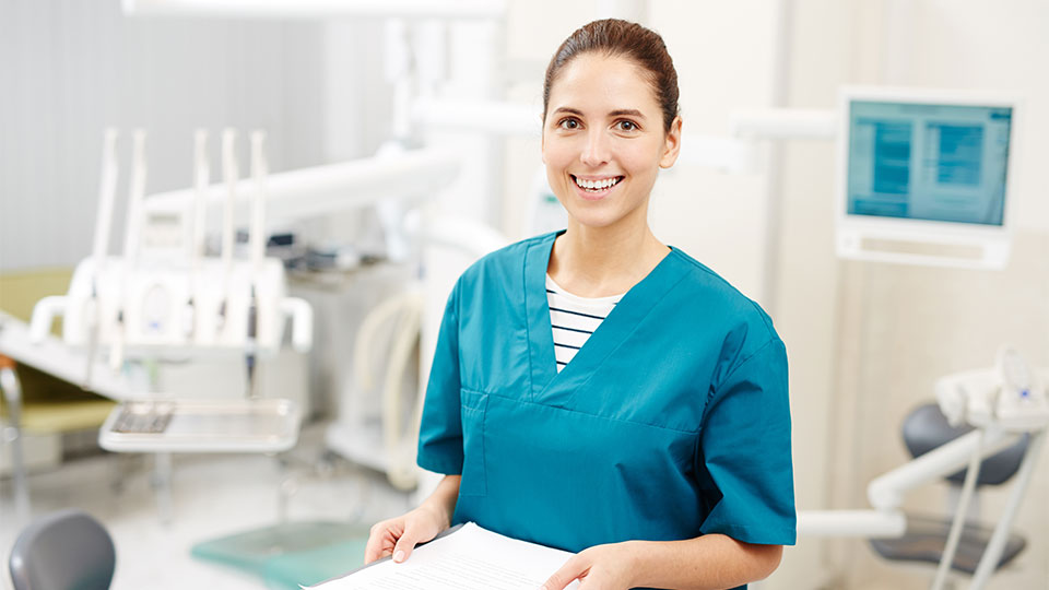 A women dressed in scrubs working in dentist office