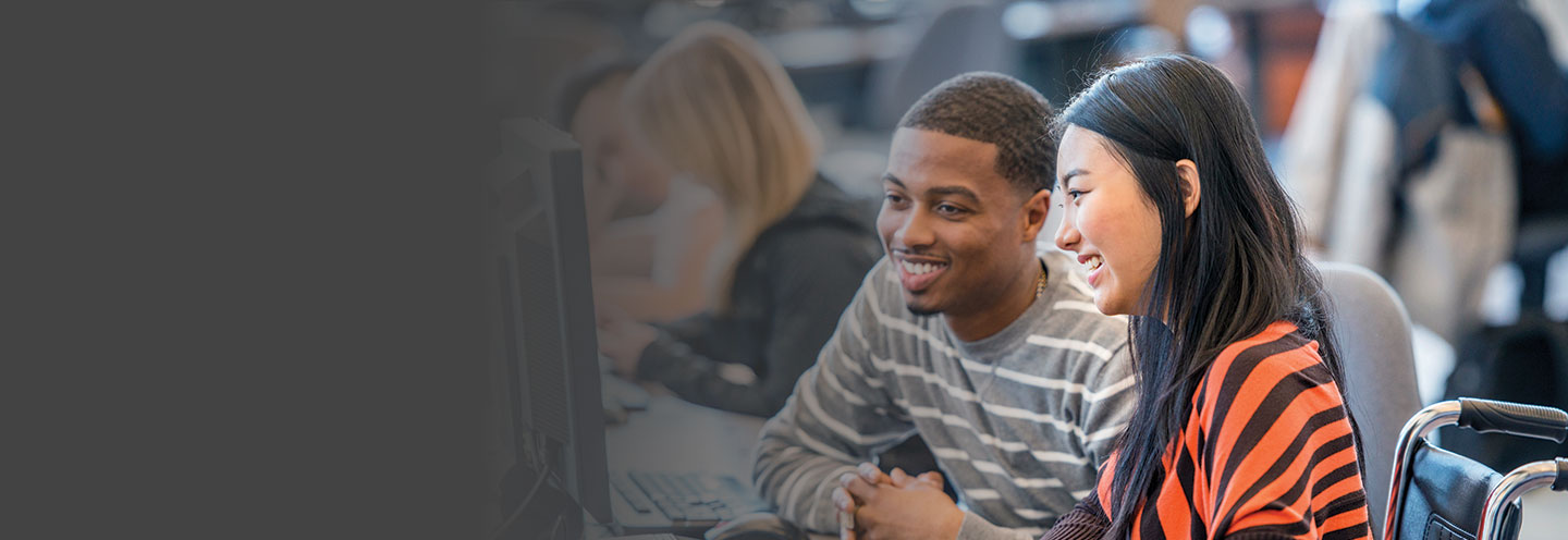 A male and female student sharing a computer