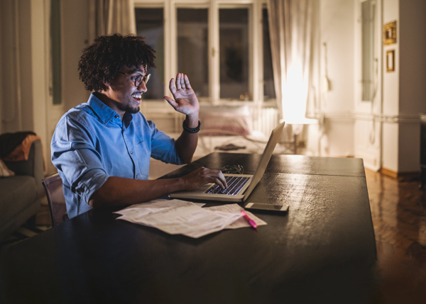 A male student taking an online course who is raising his hand to ask a question.