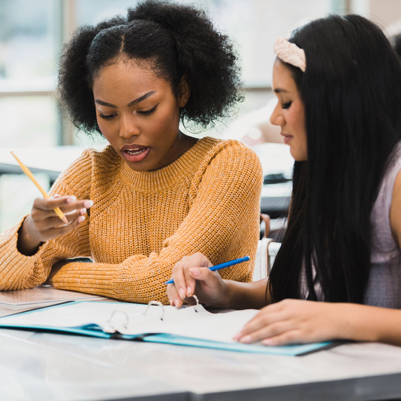 A female student tutoring another student