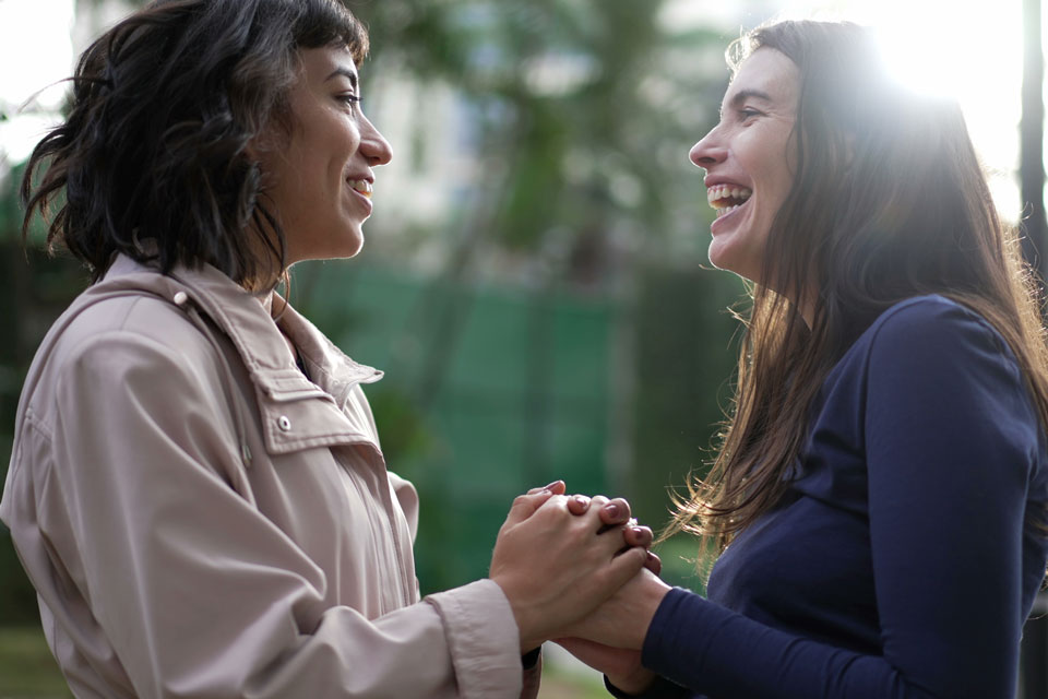 Two women embracing hands