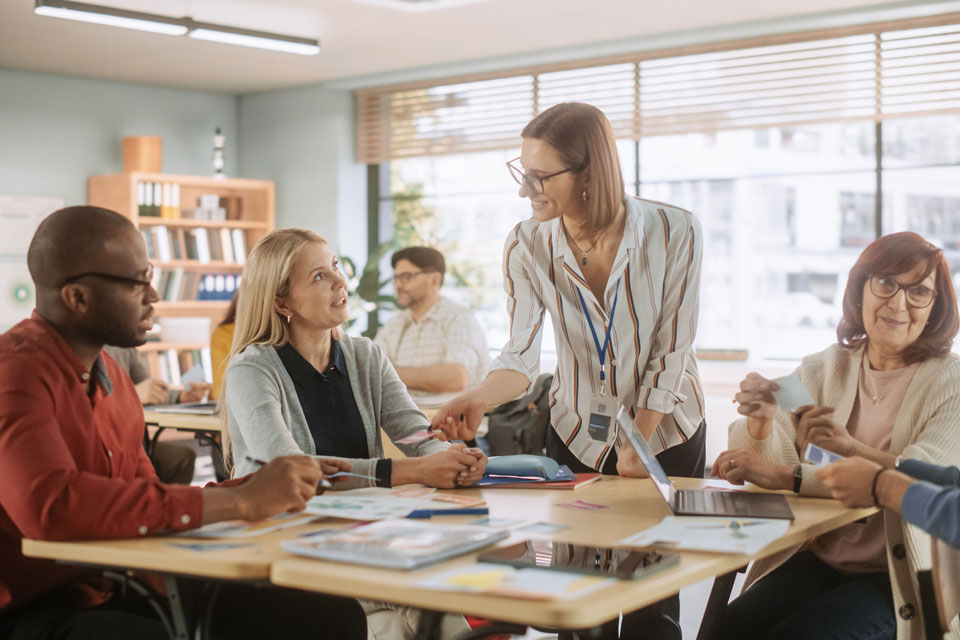 A women standing at a table facilitating a workshop